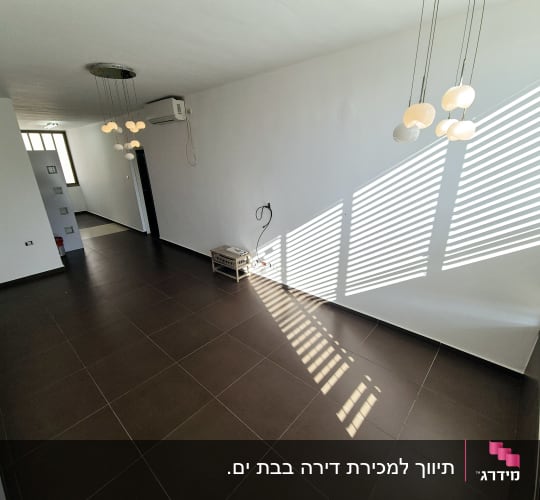 חדר ריק עם רצפת אריחים חומים ותאורה תלויה